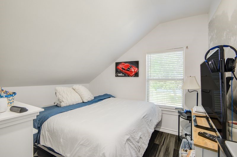 1256 2nd Street Clute, TX 77531 - Photo 30 of 43 a bedroom with a bed and a dresser next to a window