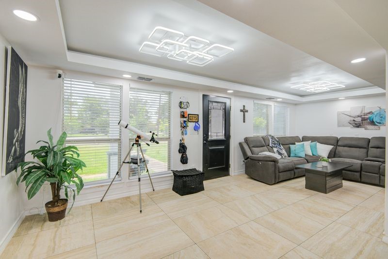 1256 2nd Street Clute, TX 77531 - Photo 6 of 43 a living room with furniture a chandelier and a potted plant