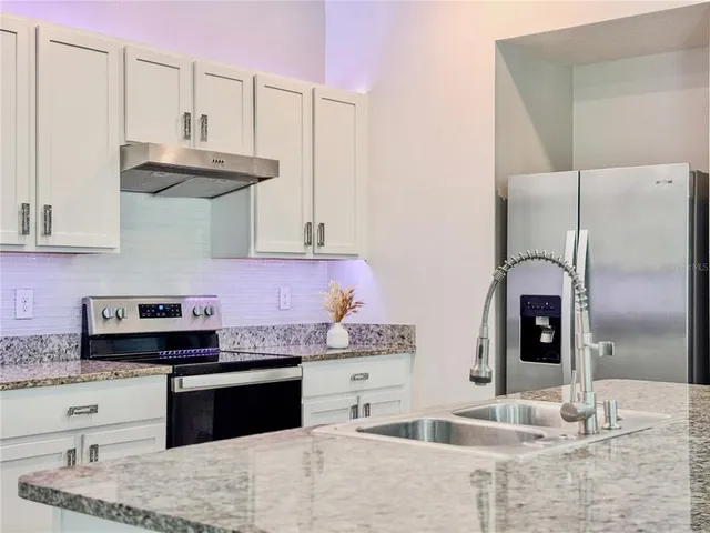 a kitchen with granite countertop stainless steel appliances sink and cabinets
