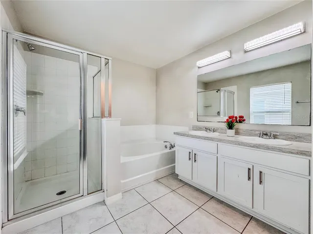 a bathroom with a granite countertop bathtub sink vanity mirror and toilet