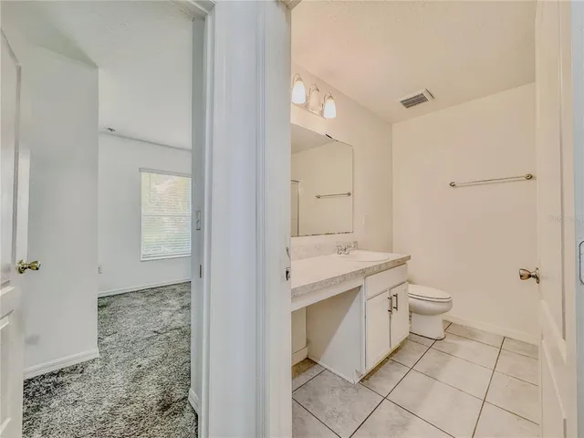 a bathroom with a granite countertop sink a toilet and shower