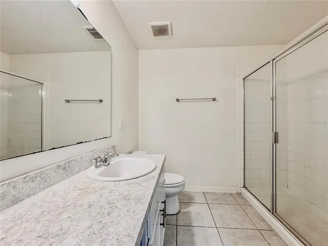 a bathroom with a granite countertop sink a mirror and a shower