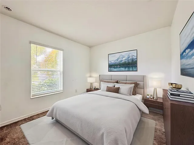 a large bed sitting in a bedroom next to a window