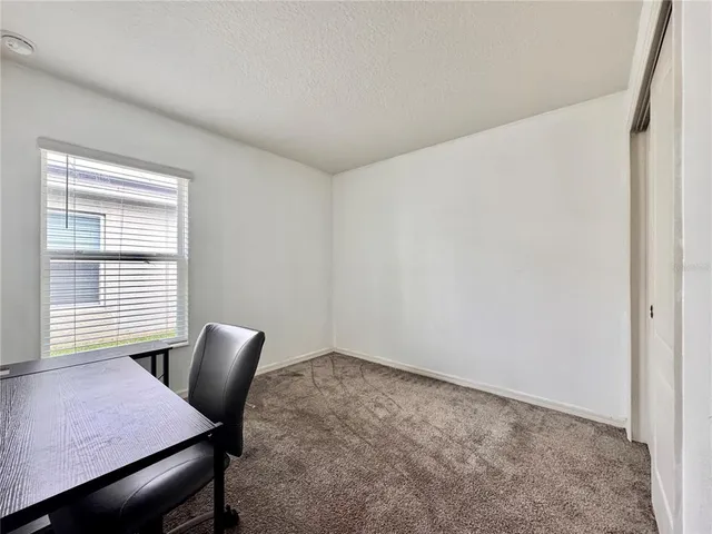 a view of a workspace with furniture and a window