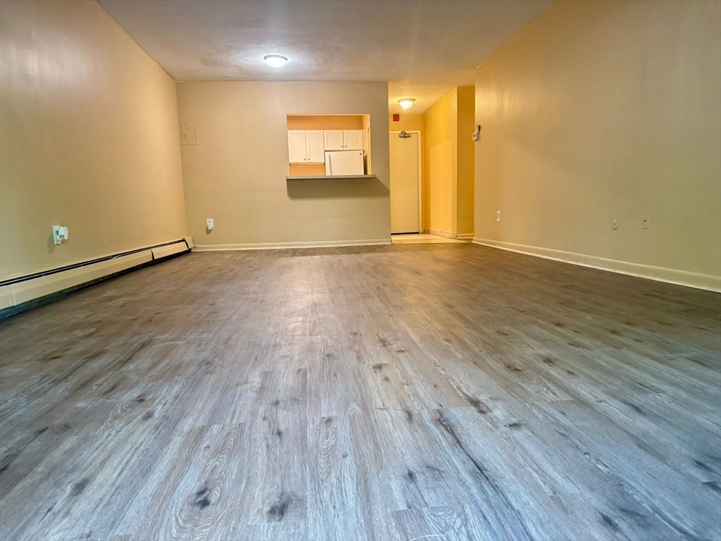 32 Whites Avenue, Unit E112 Watertown, MA 02472 - Photo 1 of 41 an empty room with wooden floor and windows