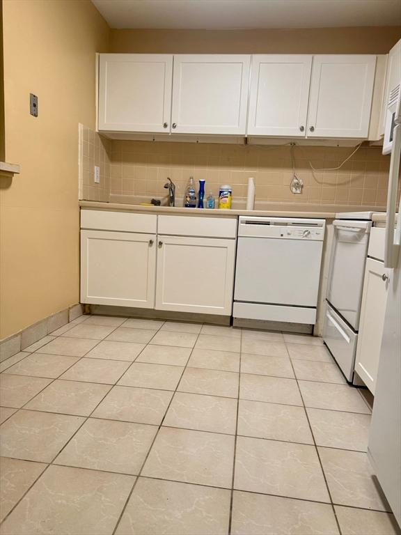 32 Whites Avenue, Unit E112 Watertown, MA 02472 - Photo 11 of 41 a utility room with cabinets washer and dryer