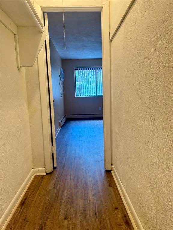 32 Whites Avenue, Unit E112 Watertown, MA 02472 - Photo 22 of 41 a view of an empty room with wooden floor and a window