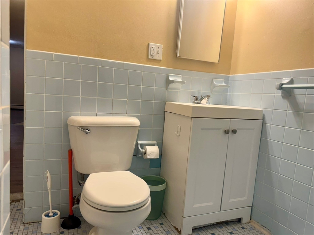 32 Whites Avenue, Unit E112 Watertown, MA 02472 - Photo 27 of 41 a white toilet sitting next to a bathroom sink