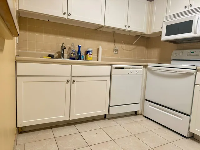 a kitchen with white cabinets and white appliances