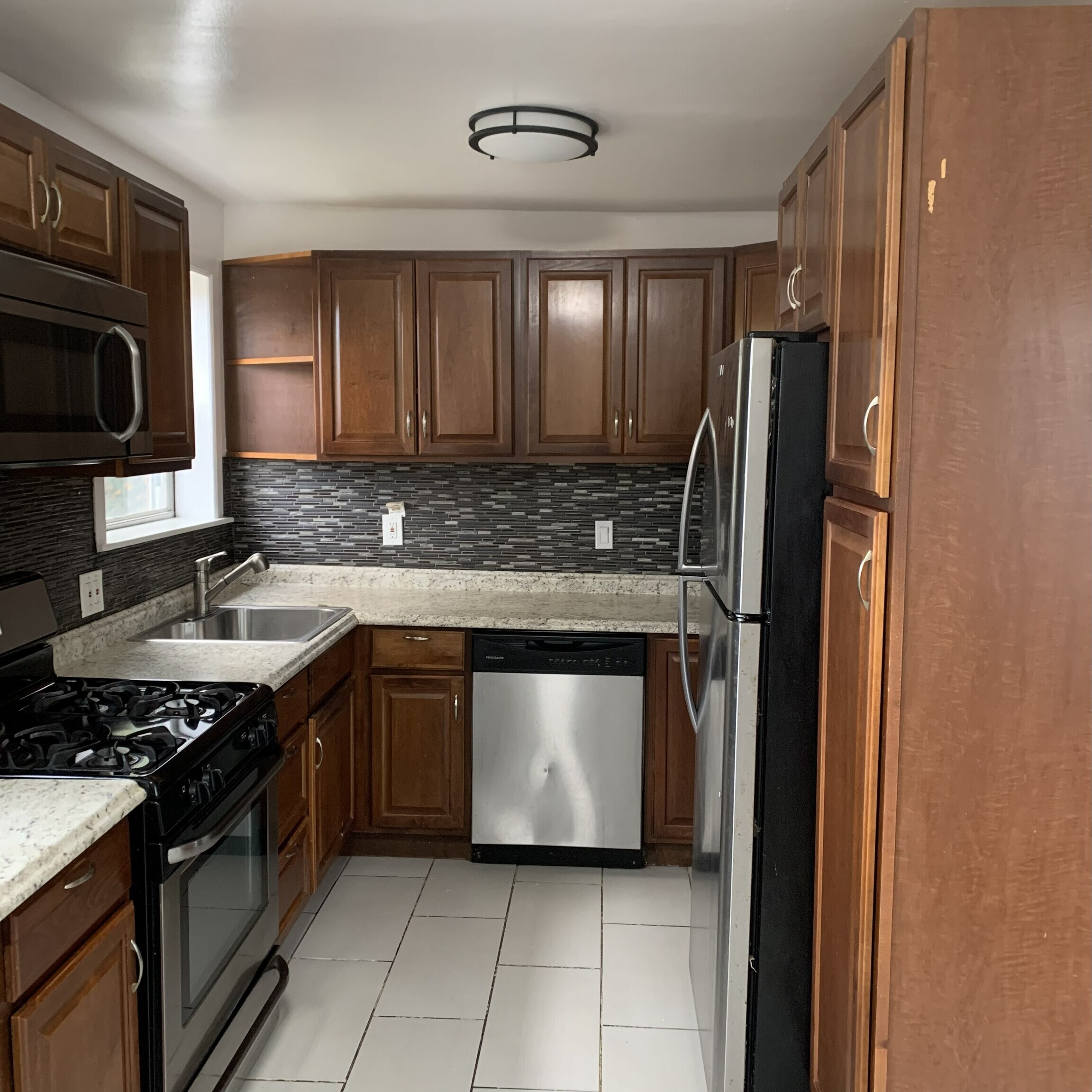 11 Bedford Avenue, Unit J1 Norwalk, CT 06850 - Photo 4 of 10 a kitchen with stainless steel appliances granite countertop a stove a sink and a refrigerator