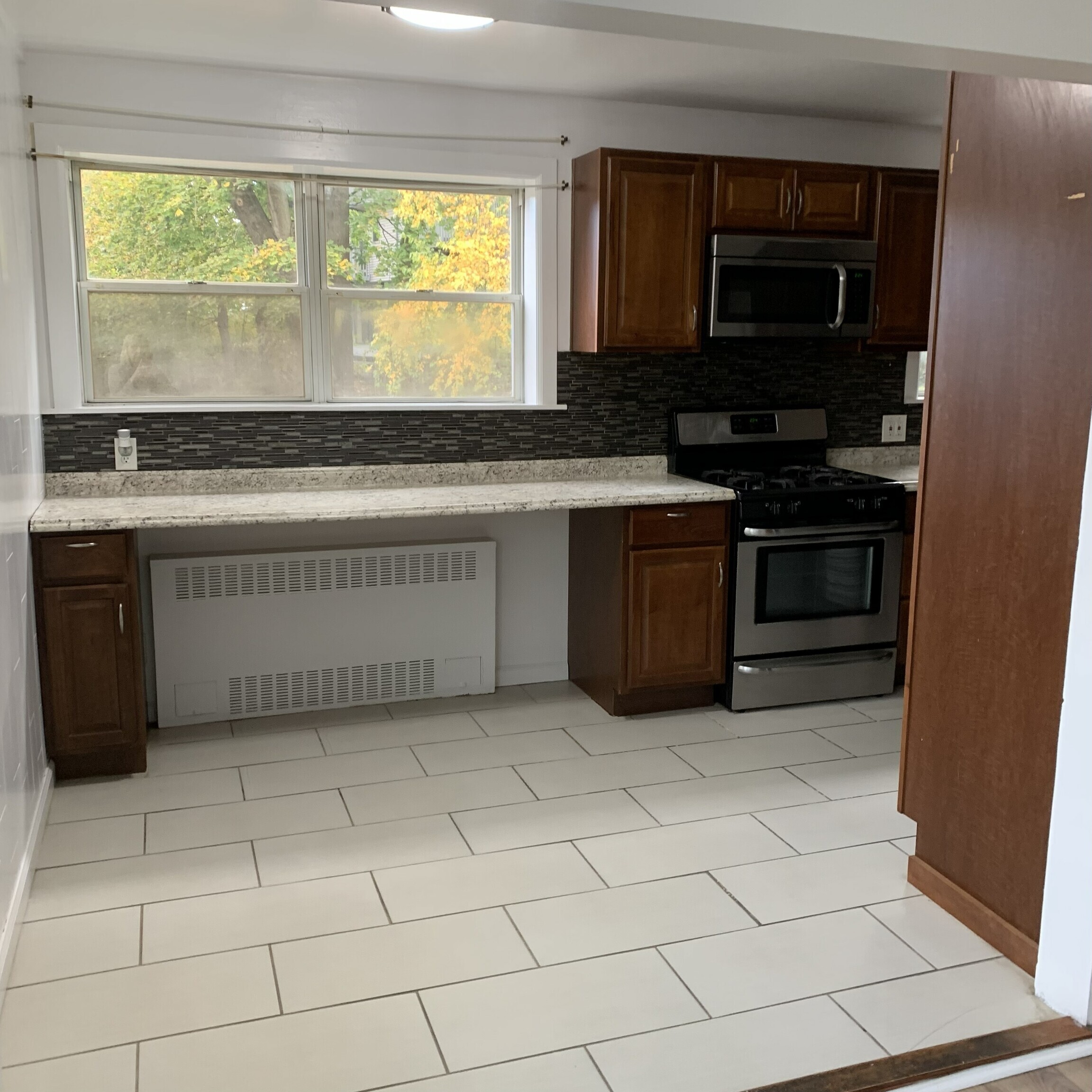 11 Bedford Avenue, Unit J1 Norwalk, CT 06850 - Photo 5 of 10 a kitchen with a stove and a microwave