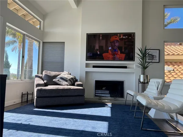 a living room with furniture a fireplace and a large window