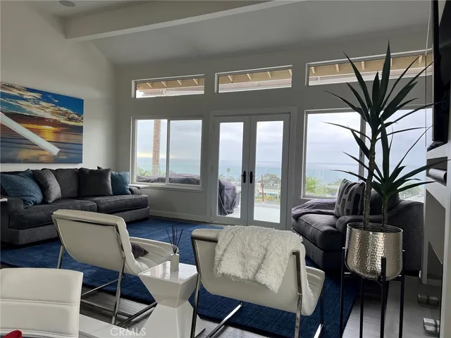 a living room with furniture a fireplace and a large window