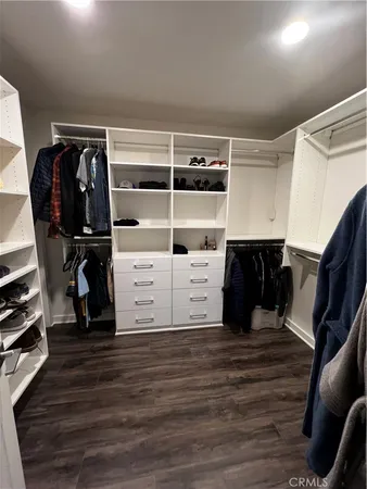 a view of walk in closet with clothes and shoes