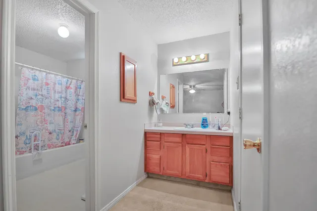 a en suite bathroom with a granite countertop sink and a mirror