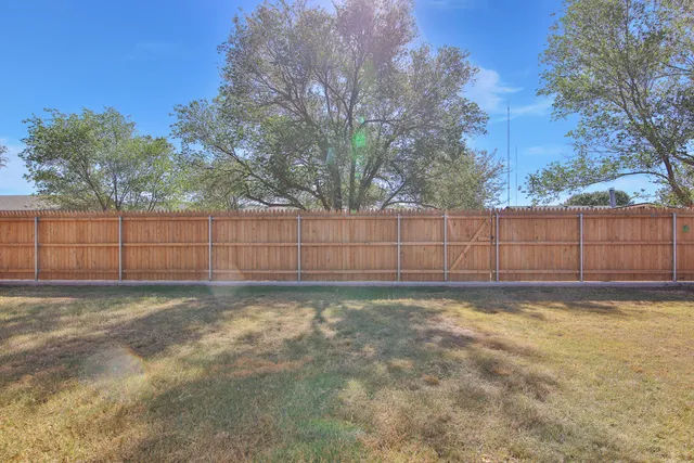 a view of a yard with wooden fence