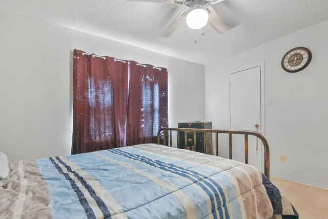 a bedroom with a large bed and a chandelier