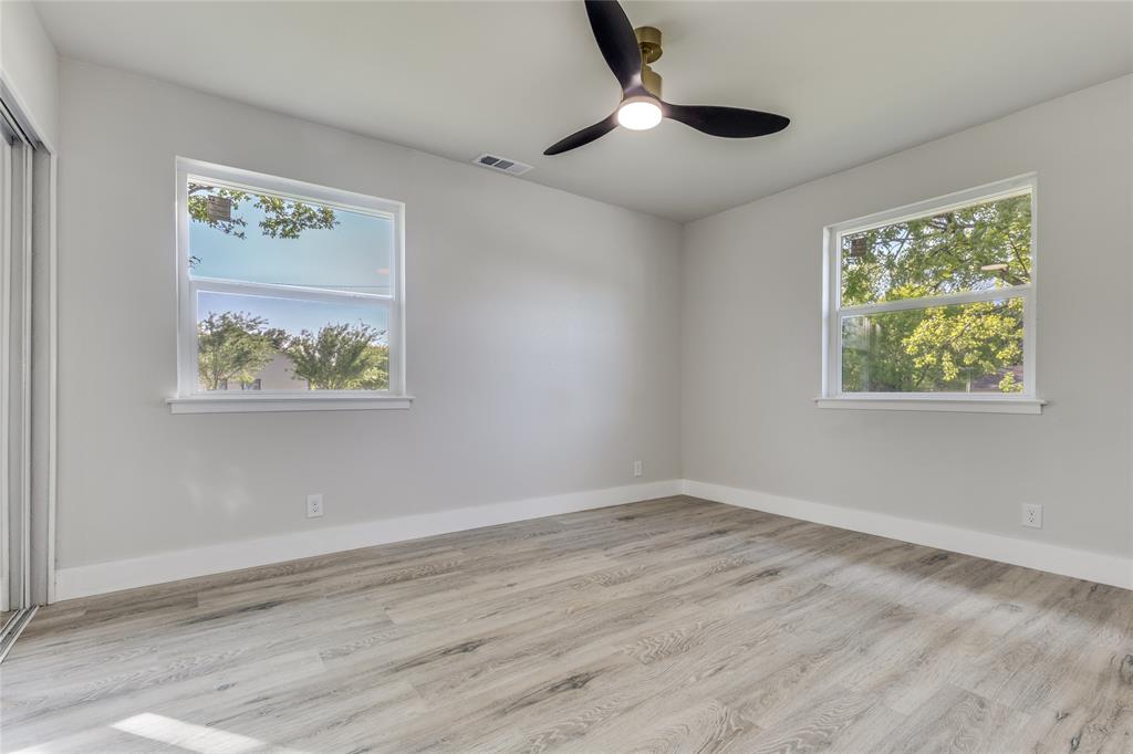 14234 Queens Chapel Road Farmers Branch, TX 75234 - Photo 11 of 21 a view of an empty room with wooden floor and ceiling fan