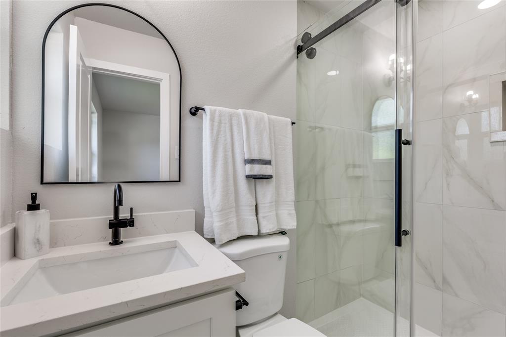 14234 Queens Chapel Road Farmers Branch, TX 75234 - Photo 12 of 21 a bathroom with a sink a toilet and a mirror