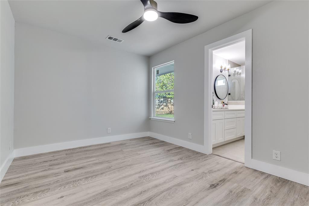 14234 Queens Chapel Road Farmers Branch, TX 75234 - Photo 13 of 21 an empty room with wooden floor cabinet and windows