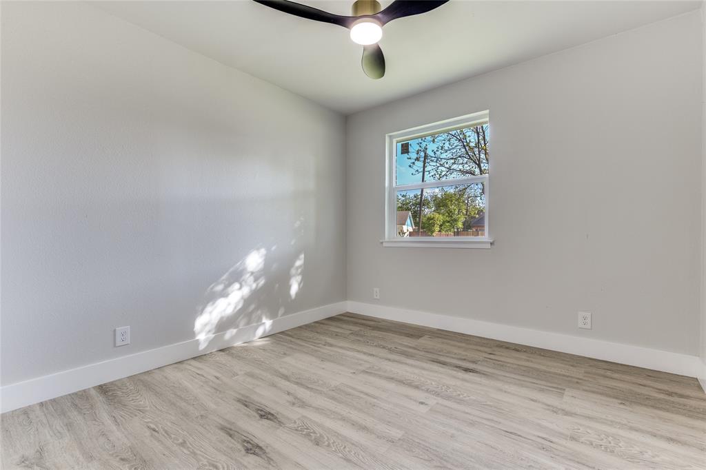 14234 Queens Chapel Road Farmers Branch, TX 75234 - Photo 17 of 21 an empty room with wooden floor and windows