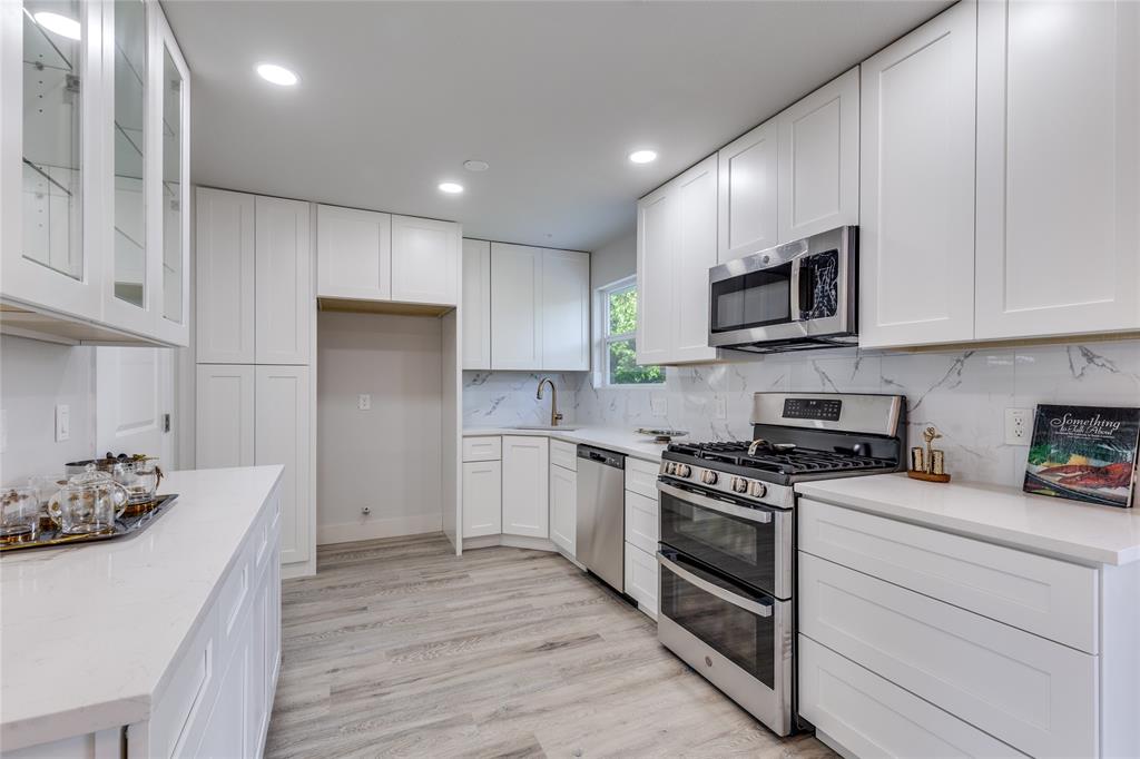 14234 Queens Chapel Road Farmers Branch, TX 75234 - Photo 8 of 21 a kitchen with stainless steel appliances granite countertop a stove a sink and a refrigerator