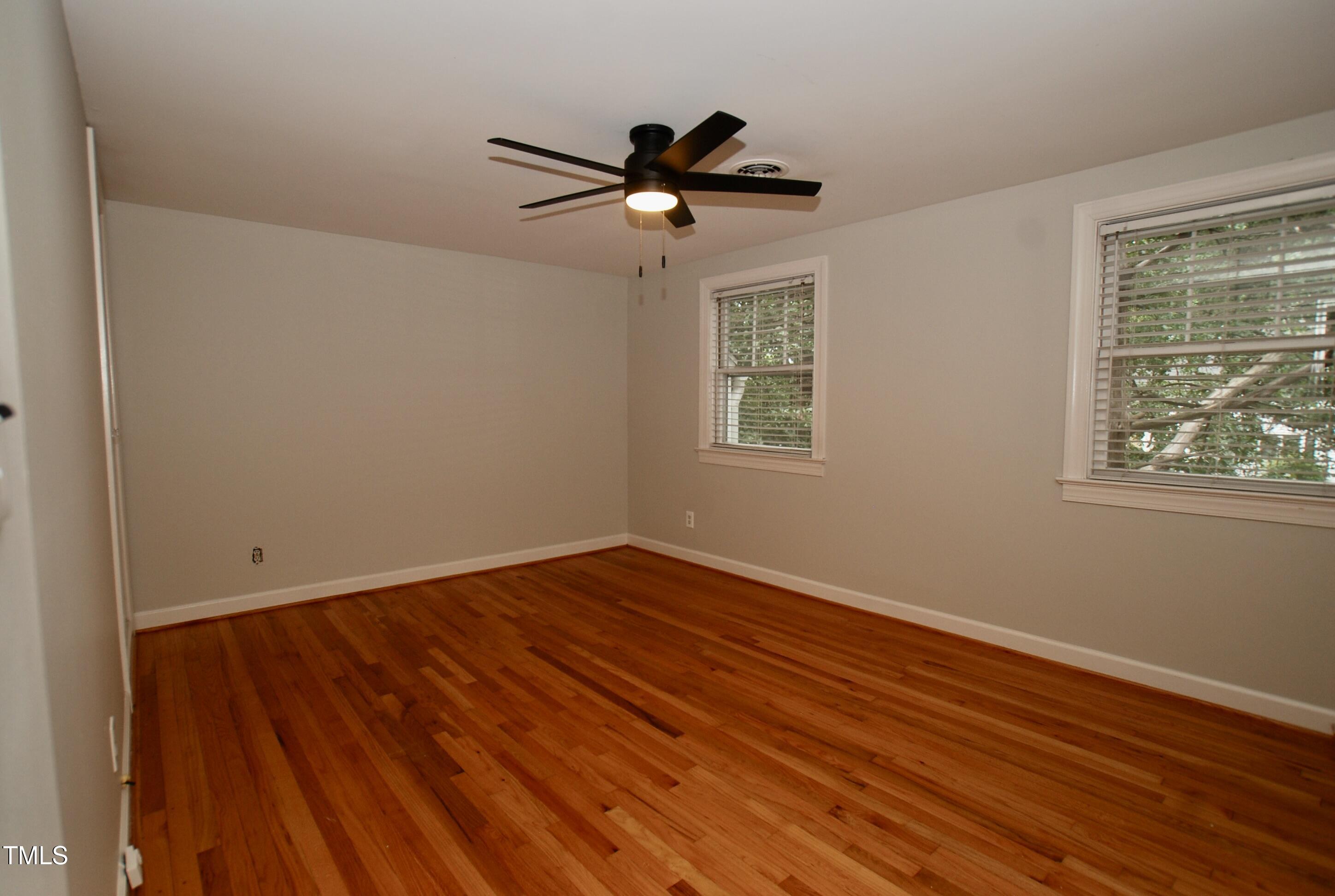 1908 Smallwood Drive Raleigh, NC 27605 - Photo 11 of 30 a view of empty room with wooden floor and fan