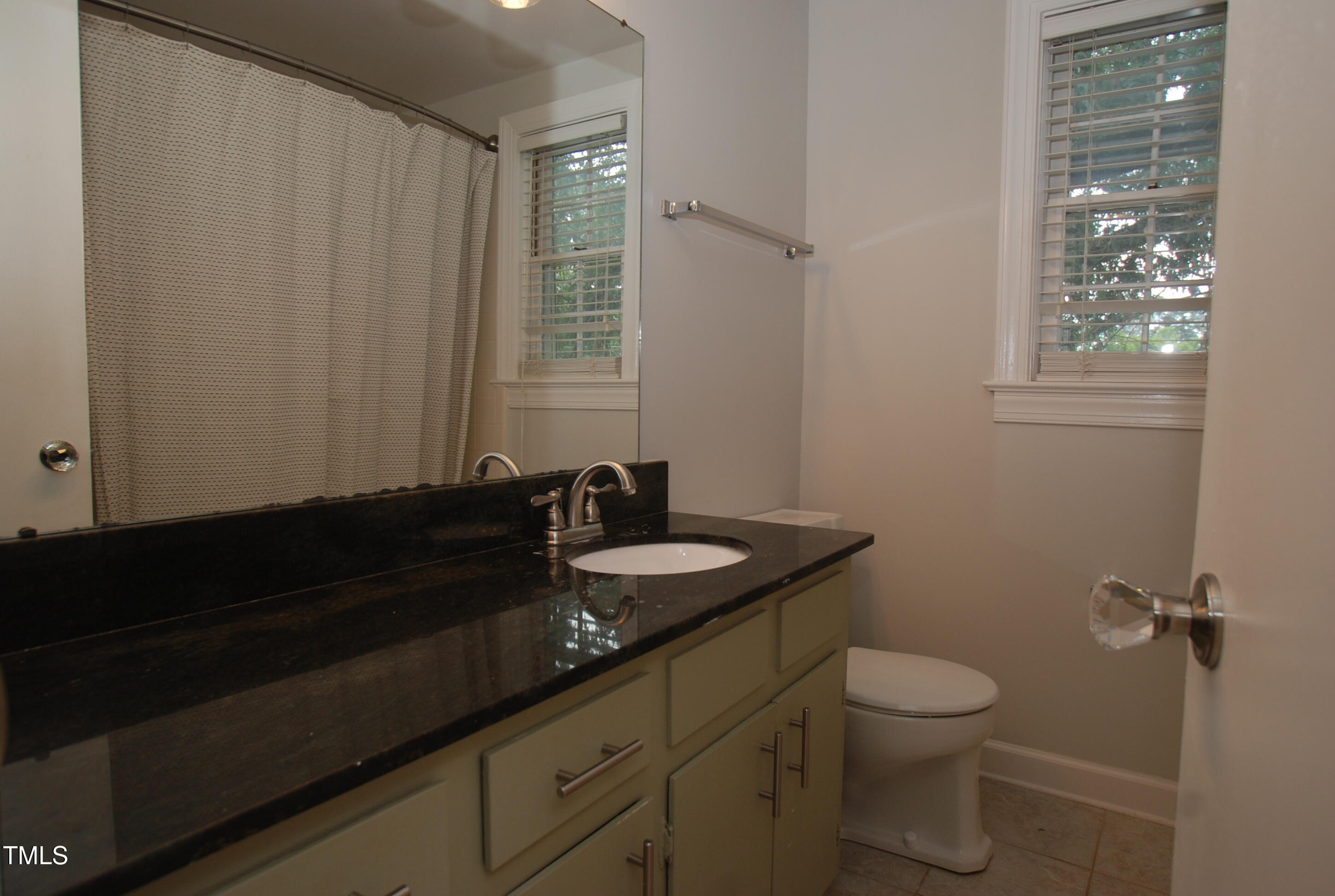 1908 Smallwood Drive Raleigh, NC 27605 - Photo 10 of 30 a bathroom with a granite countertop sink toilet and a mirror