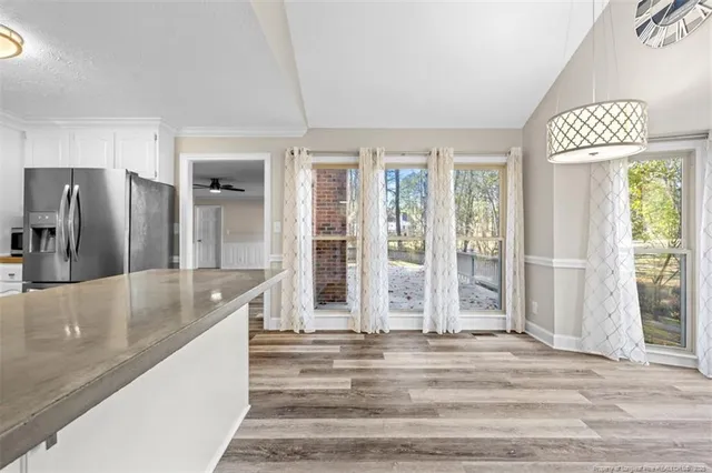 a view of a kitchen with granite countertop a refrigerator and a sink