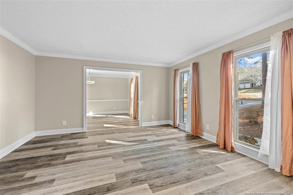 6922 South Staff Road Fayetteville, NC 28306 - Photo 9 of 45 a view of an empty room with wooden floor and a window