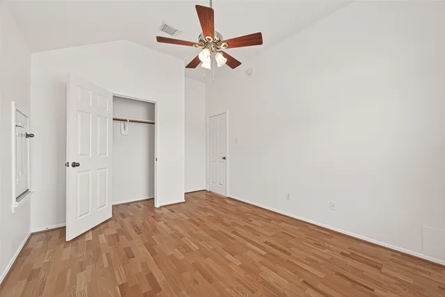 a view of empty room with wooden floor