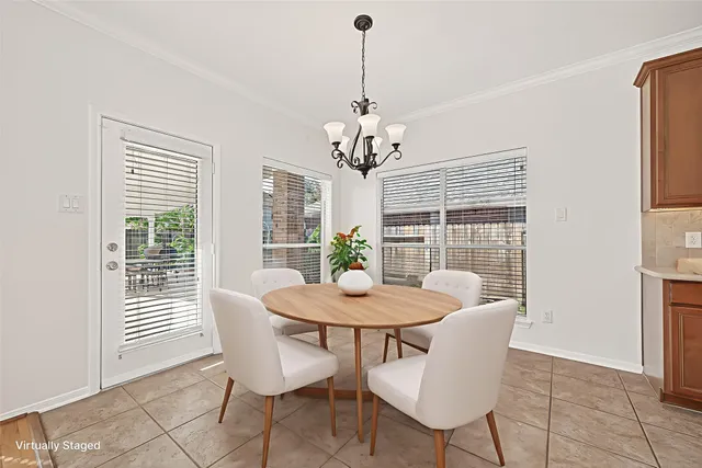 a dining room with furniture a chandelier and window
