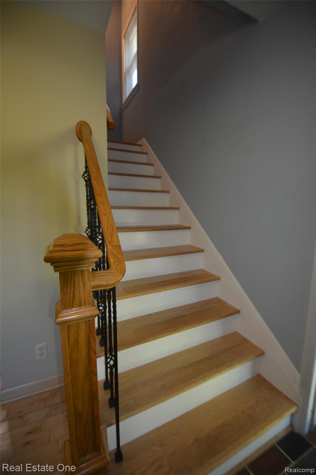 615 Willard Avenue Rochester, MI 48307 - Photo 14 of 30 Staircase featuring wood-finish treads, white risers, a wood newel post, and an ornate wrought iron baluster system