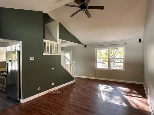 a view of a room with window ceiling fan and hardwood floor
