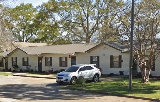 a white house that has a tree in front of it