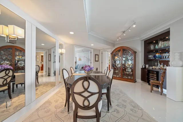 a view of a dining room and livingroom with furniture a rug a painting and a chandelier