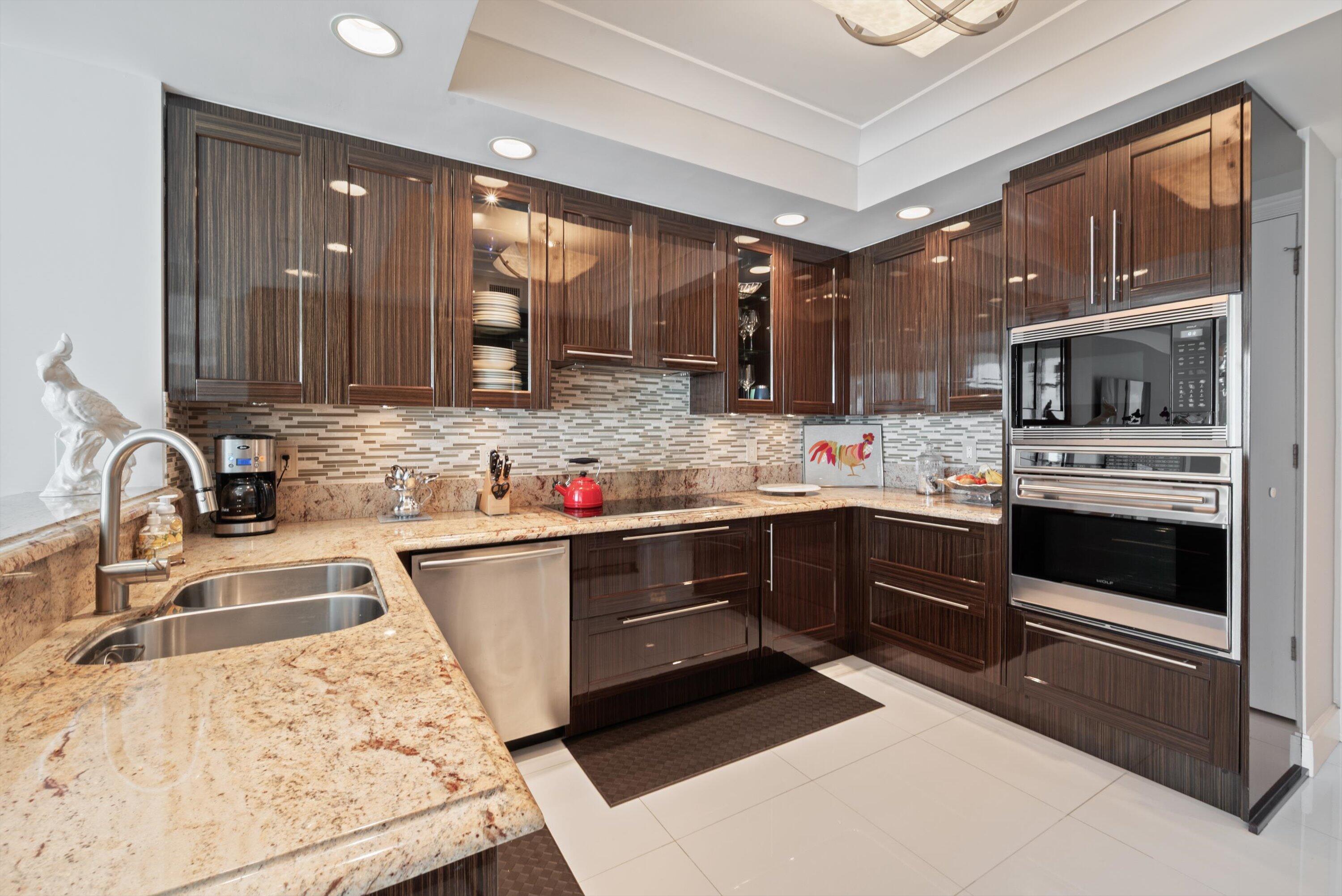 2700 North Ocean Drive, Unit 1401B Singer Island, FL 33404 - Photo 15 of 49 a kitchen with stainless steel appliances kitchen island granite countertop a sink stove and cabinets