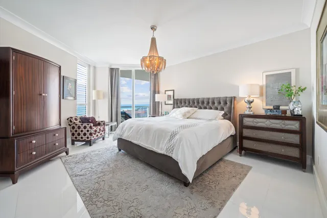 a bedroom with a large bed and a chandelier