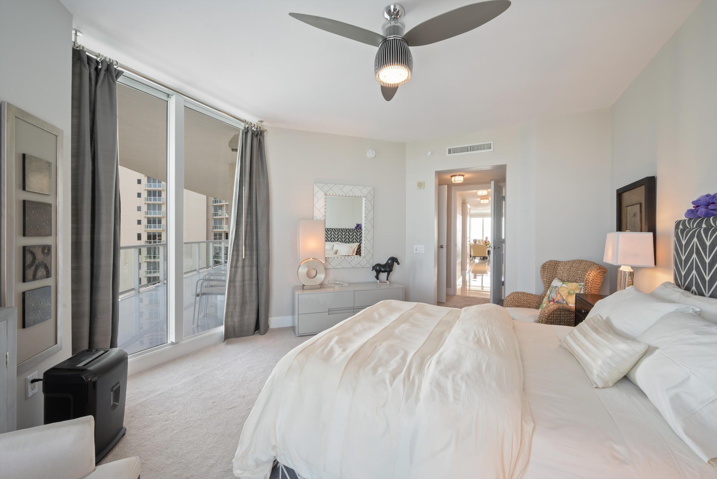 2700 North Ocean Drive, Unit 1401B Singer Island, FL 33404 - Photo 20 of 49 a bedroom with a large bed and a chandelier