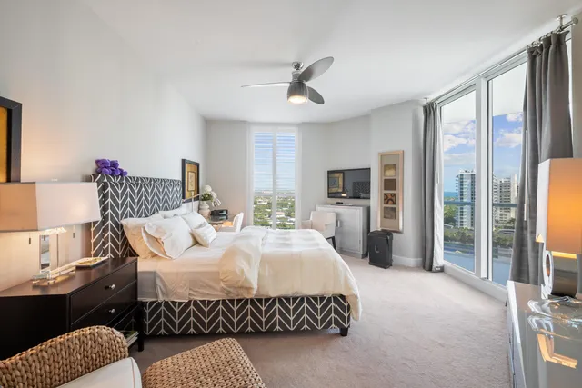 a bedroom with a bed couch and a large window