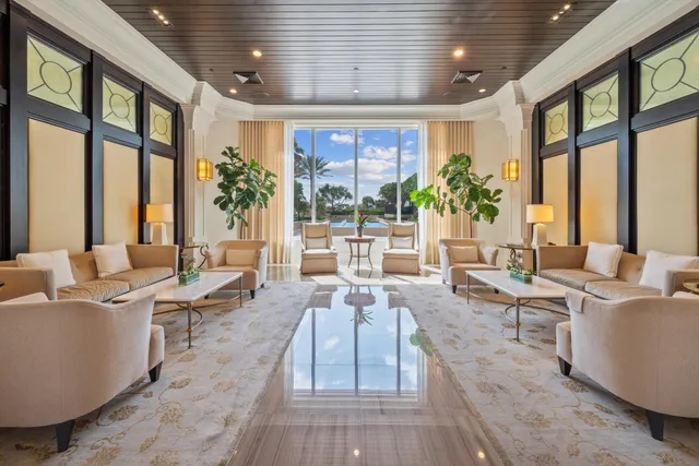 a living room with furniture large windows and wooden floor