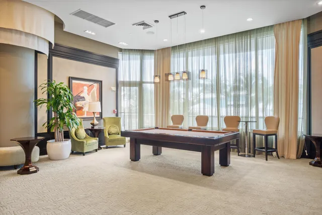 a room with furniture pool table and windows