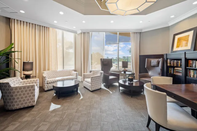 a living room with furniture and large windows