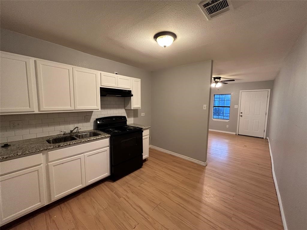 6818 Weston Street, Unit 1 Houston, TX 77021 - Photo 3 of 10 a kitchen with granite countertop a stove and a wooden floors