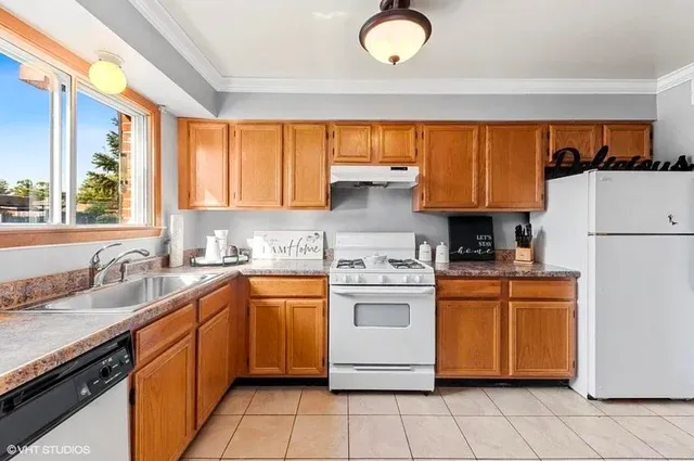 a kitchen with a sink a stove top oven and cabinets