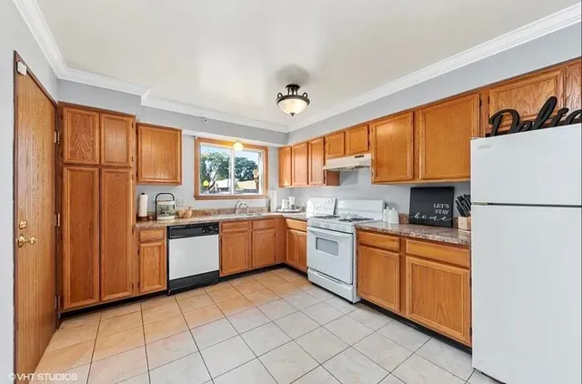 a kitchen with stainless steel appliances granite countertop a refrigerator a sink dishwasher a stove with white cabinets and wooden floor