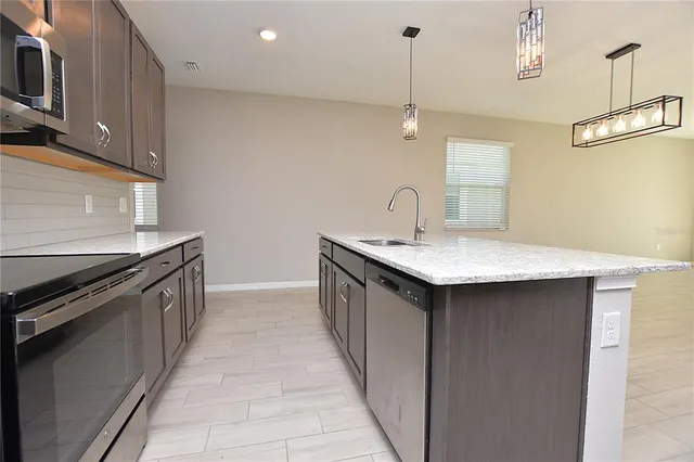 a kitchen with granite countertop a sink and a stove