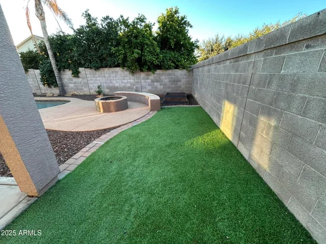 a backyard of a house with table and chairs