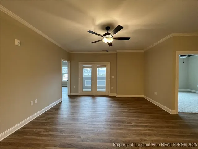 a view of an empty room with window and wooden floor
