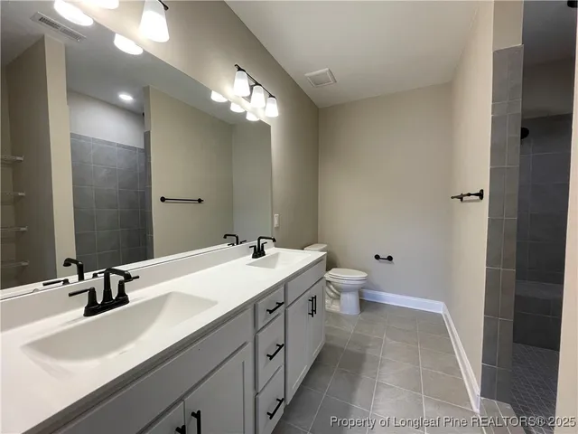 a bathroom with a double vanity sink toilet and a mirror